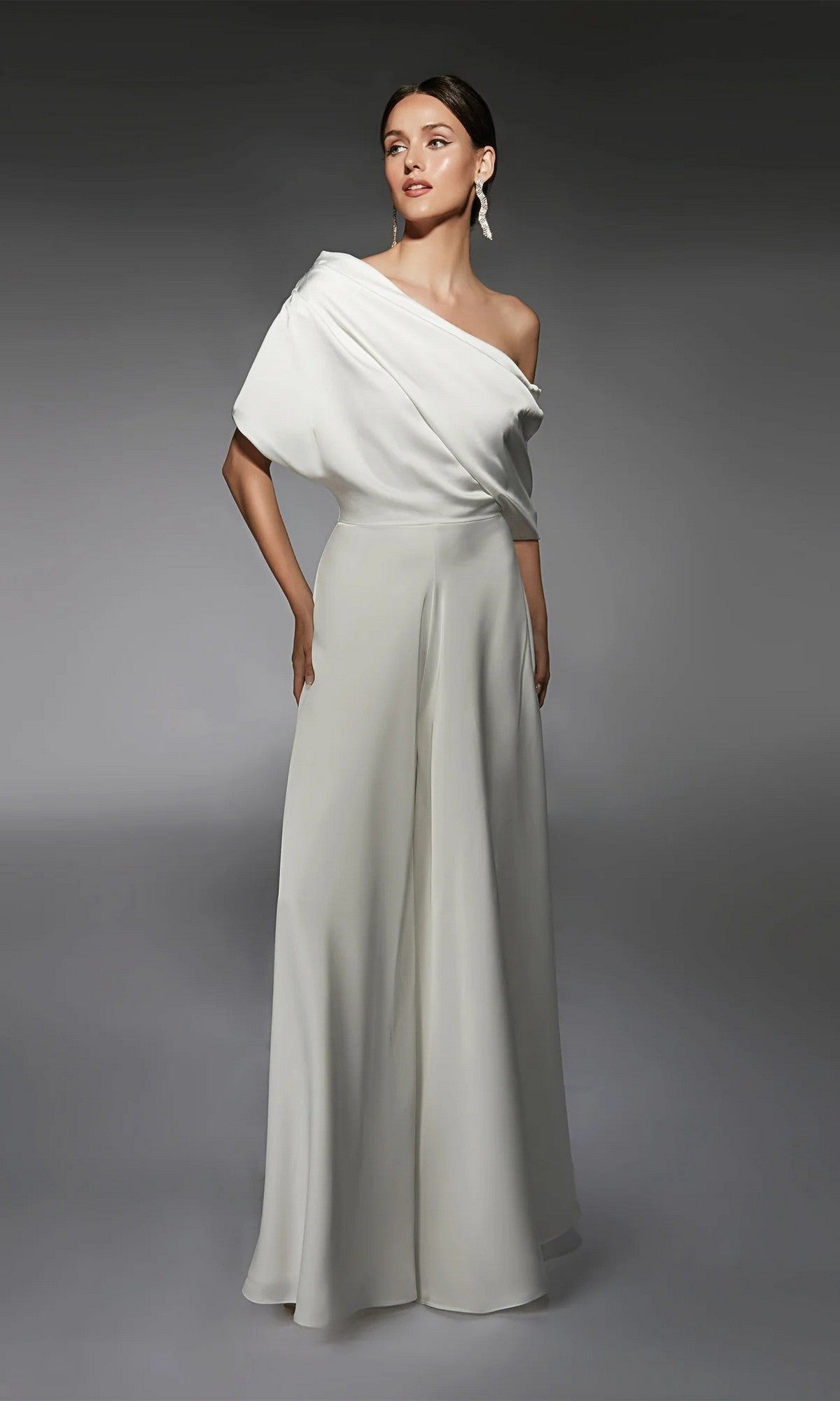 Woman wearing the Long White Jumpsuit: Alyce 70072, featuring wide-leg pants, stands against a plain gray background.
